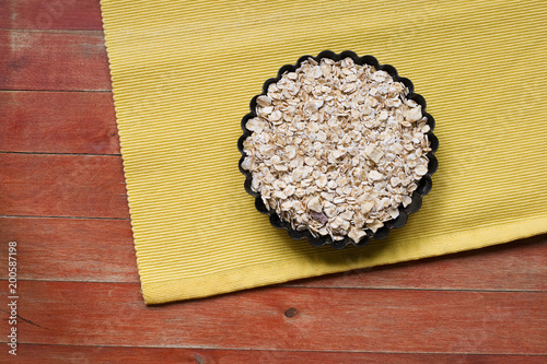 The process of prepare  tart. Black iron form for pie. Oatmeal pastry. Wooden background. Rustic style. Copy space.