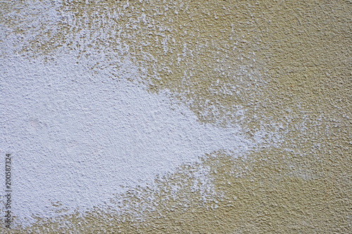 Textured concrete wall beige yellow, brushstrokes of white paint.