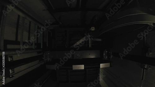 In a dark elevator shaft, the cabin moves up one floor and stops there.
