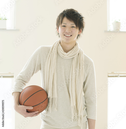 部屋でバスケットボールを持ち微笑む男性 photo