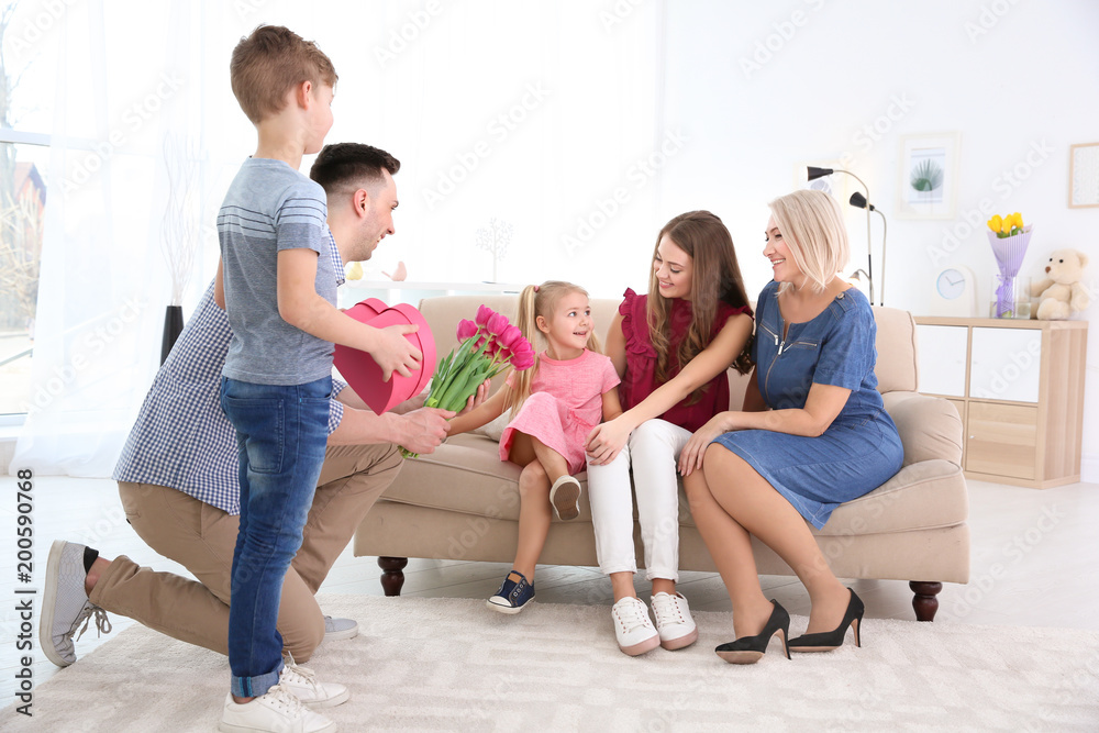 Man and little boy congratulating women at home Man and little boy congratulating women at home