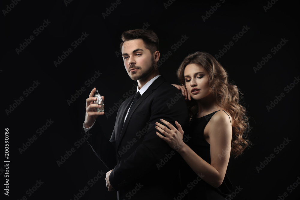 Passionate woman and handsome man using perfume on black background Passionate woman and handsome man using perfume on black background