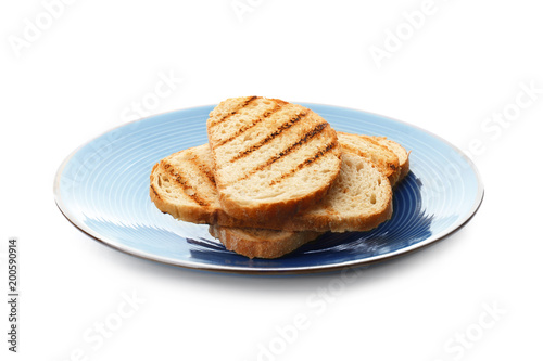 Plate with toasted bread on white background