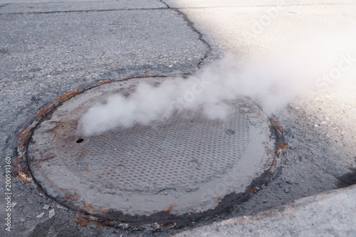 Heavy steam coming out of a city center sewer. photo