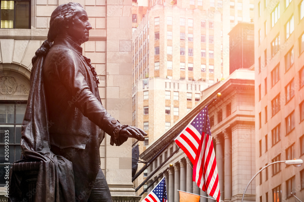 Fototapeta premium Wall Street w Nowym Jorku o zachodzie słońca z posągiem George'a Washingtona w Federal Hall