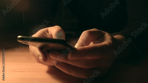 Man writng sms on iphone. Night mood. photo