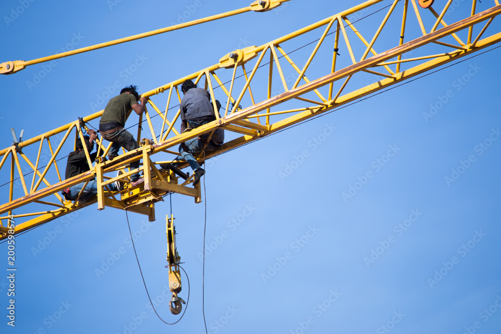 Group of labour working on the tower crane.