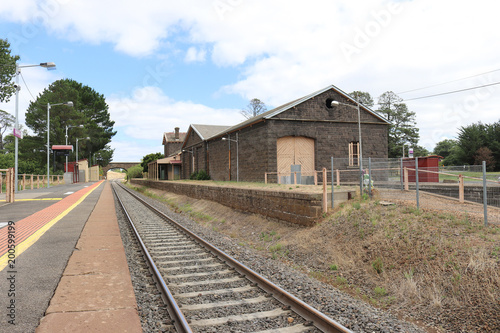 train tracks and a bluestone railway station building and platform