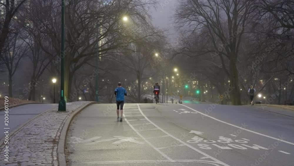 Jogger running down the street as cyclists ride by in the morning in New York City. Jogger running down the street as cyclists ride by in the morning in New York City.