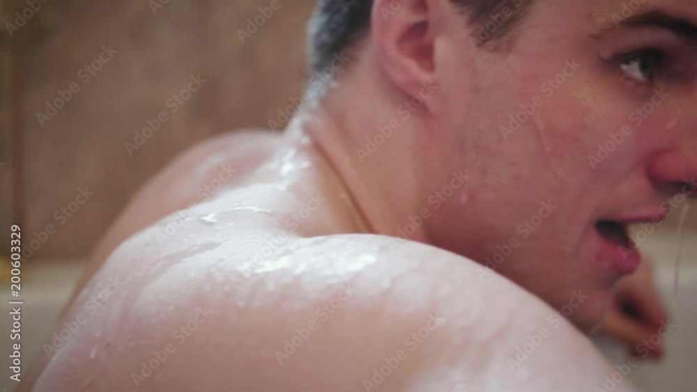 Camera pans across the wet body of a young attractive athlete sitting in an ice bath after a work out SLOW MOTION CLOSE UP Camera pans across the wet body of a young attractive athlete sitting in an ice bath after a work out SLOW MOTION CLOSE UP