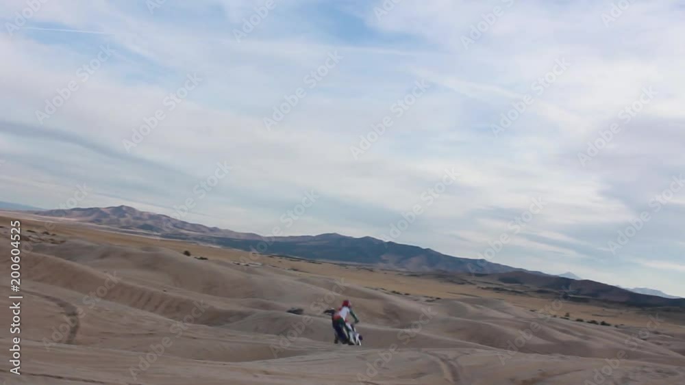 Dirt bike rider jumping over huge sane dunes Dirt bike rider jumping over huge sane dunes