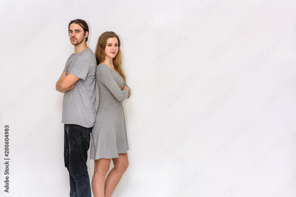 young and beautiful man and woman are standing on white background in different poses