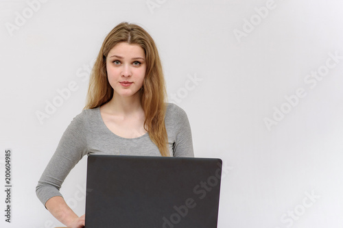 beautiful young girl sitting at the table with a laptop in different poses