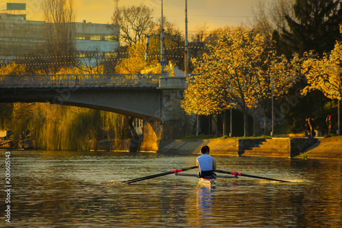 Rowing at sunset on the Bega River with Mary (Maria) / Traian bridge in Timisoara, Romania 