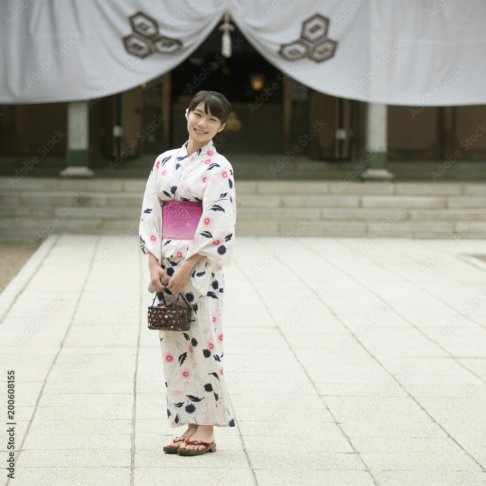 神社の境内で微笑む浴衣姿の女性 神社の境内で微笑む浴衣姿の女性