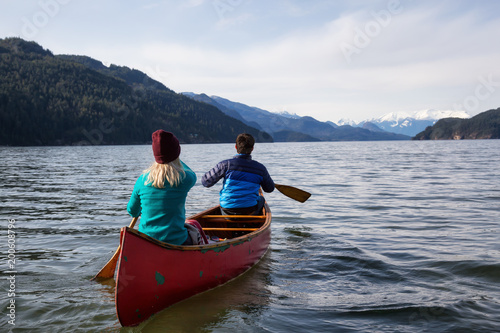 Couple friends canoeing on a wooden canoe during a sunny day. Taken in Harrison Lake, East of Vancouver, British Columbia, Canada. © edb3_16