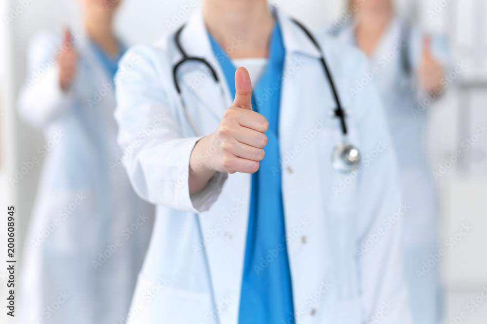 Groupe of medicine doctors show OK sign with thumb up close up. Success and high level service in health care, best treatment and customer loyalty and physical concept. Copy space for advertisement Groupe of medicine doctors show OK sign with thumb up close up. Success and high level service in health care, best treatment and customer loyalty and physical concept. Copy space for advertisement