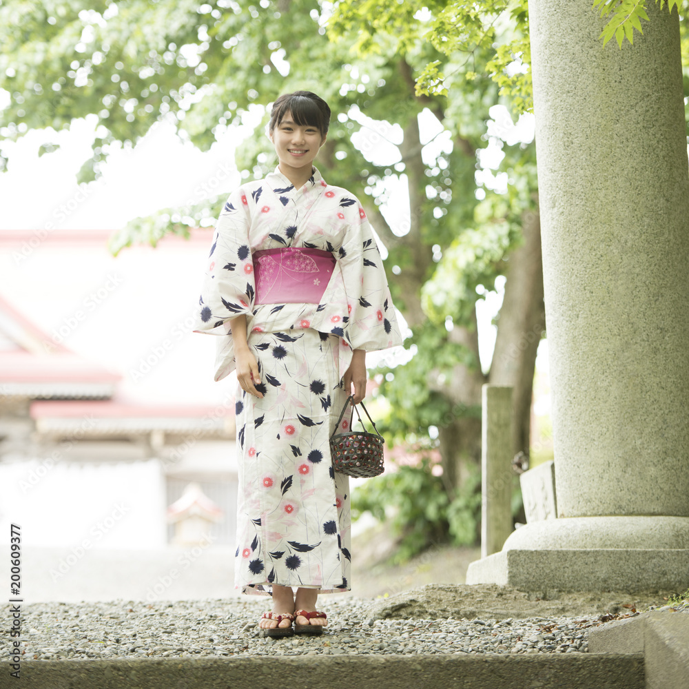 神社で微笑む浴衣姿の女性