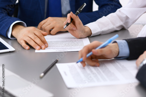 Canvas Print Group of business people and lawyer discussing contract papers sitting at the table, closeup