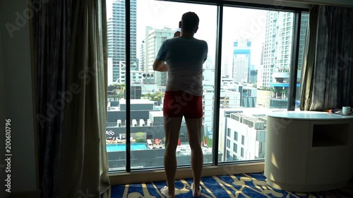 Man standing in his apartment and takes his shirt off, slow motion shot at 240fps
 photo