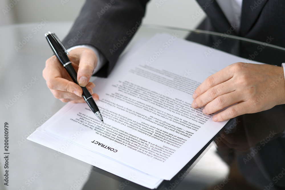 Close-up of female hands with pen over document, business concept Close-up of female hands with pen over document, business concept