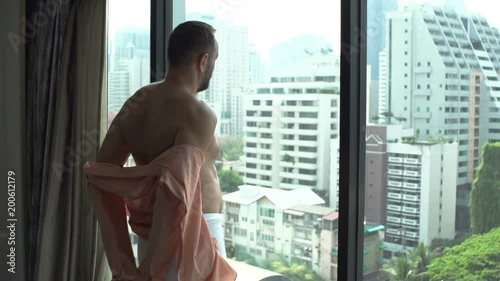 Man wearing towel and takes his shirt off while admiring the view, slow motion shot at 240fps
 photo