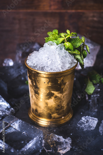 A small iron bucket stands on a table with ice. photo