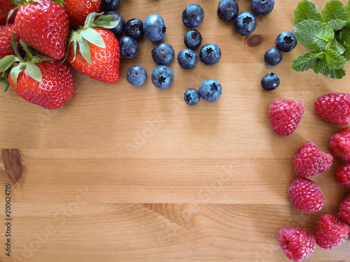 Berries mix strawberries blueberries raspberries mint on the wooden table photo