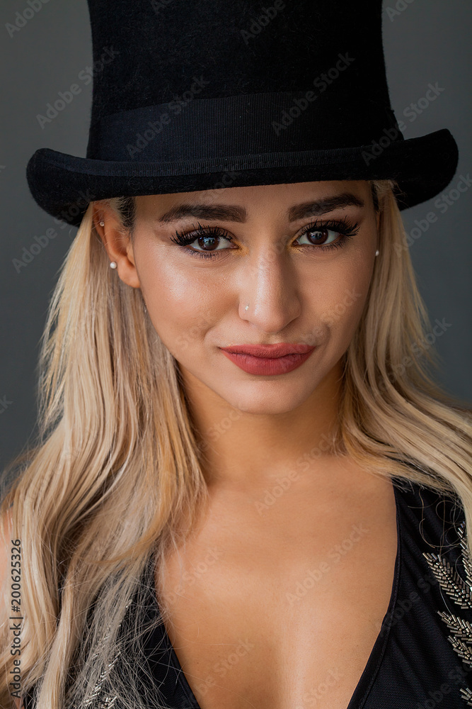 Lovely woman portrait wearing top hat and smiling while looking at camera Lovely woman portrait wearing top hat and smiling while looking at camera