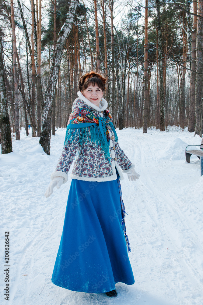 a girl with beautiful hair on her head in a Slavic style in full growth in the winter forest