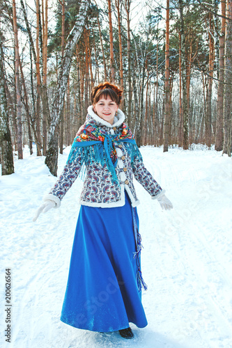 a girl with beautiful hair on her head in a Slavic style in full growth in the winter forest