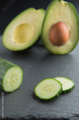 Green smoothie ingredients - avocado, cucumber on a dark background