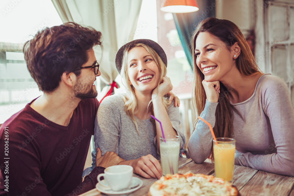 Young friends sharing pizza in a indoor cafe Young friends sharing pizza in a indoor cafe