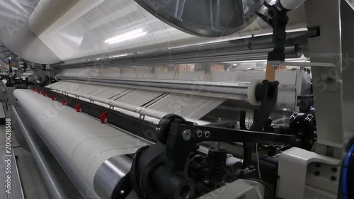 weaving loom at a textile factory, closeup. industrial fabric production line. the camera is stationary