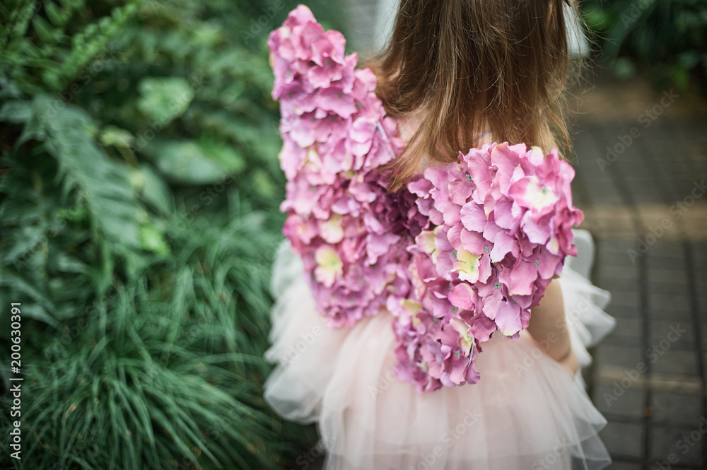 Fototapeta premium girl sniffing flowers of azaleas. flowering azaleas in the park