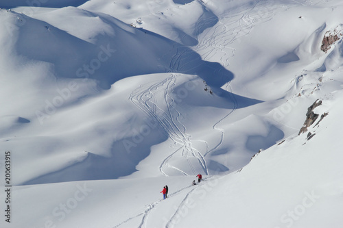 high mountains off-piste slopes for freeride with traces of skis and snowboards, sunny winter day, Caucasus Mountains, Elbrus, Russia