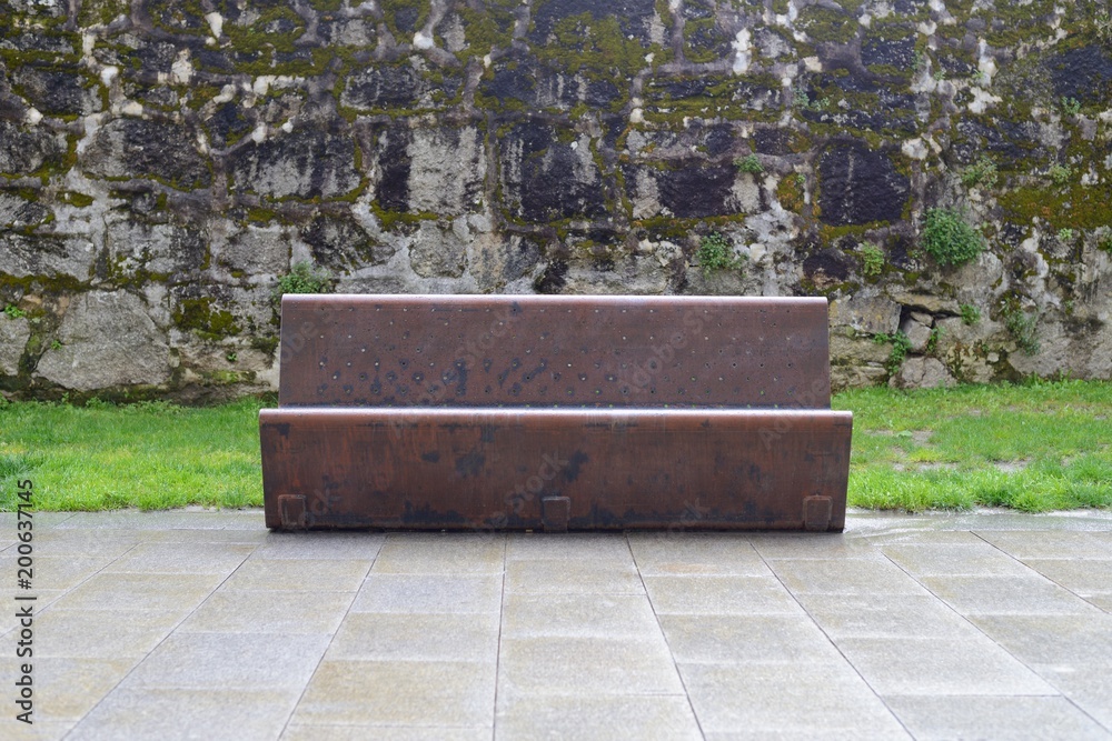 metal bench on the background of a stone wall