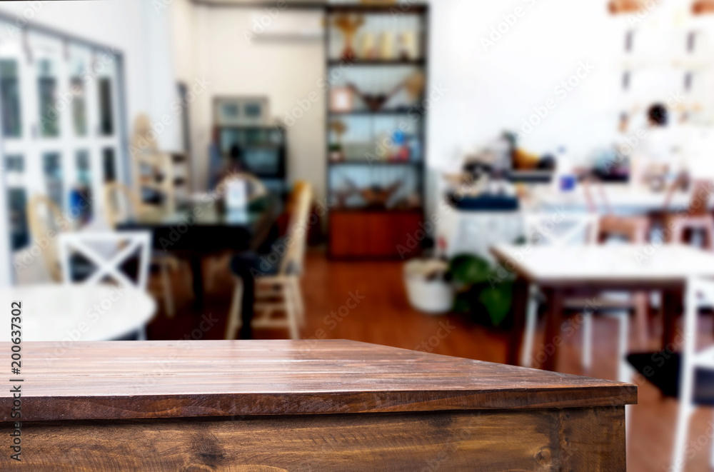 Selected focus empty brown wooden table and Coffee shop or restaurant blur background with bokeh image. for your photomontage or product display. Selected focus empty brown wooden table and Coffee shop or restaurant blur background with bokeh image. for your photomontage or product display.