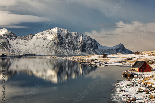 Beautiful landscape with clouds, fog, water, reflectaion in background at Lofoten Island, Norway © danmir12
