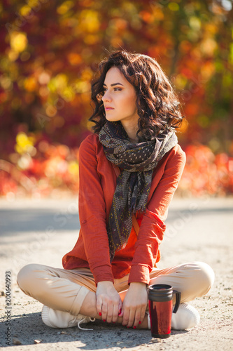 Young beautiful woman at autumn background. Portrait of attractive young girl outdoors