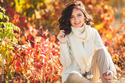 Young beautiful woman at autumn background. Portrait of attractive young girl outdoors