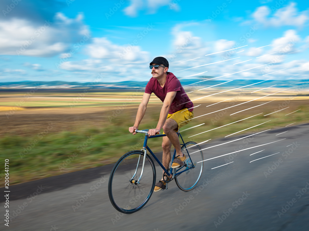 Fototapeta premium Casual hipster cyclist riding bicycle with high speed concept