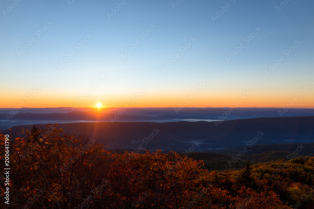Morning dark sunrise with sky and golden yellow orange autumn foliage in Dolly Sods, Bear Rocks, West Virginia with overlook of mountain valley landscape