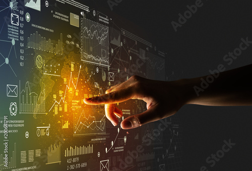 Female finger touching a beam of light surrounded by charts and graphs