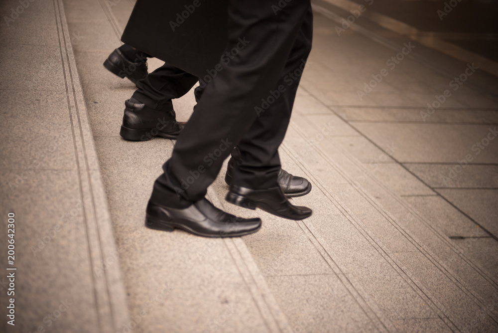 defocused or blured Businessman walking the stairs with city background, Businessmen go to success concept, vintage style. defocused or blured Businessman walking the stairs with city background, Businessmen go to success concept, vintage style.