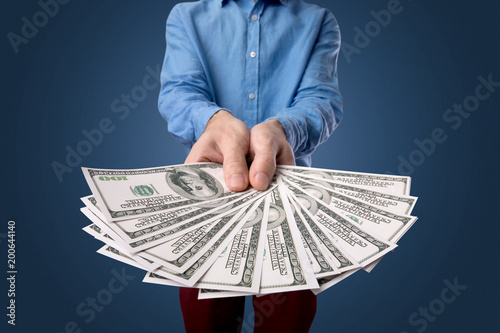 Young businessman holding large amount of bills 