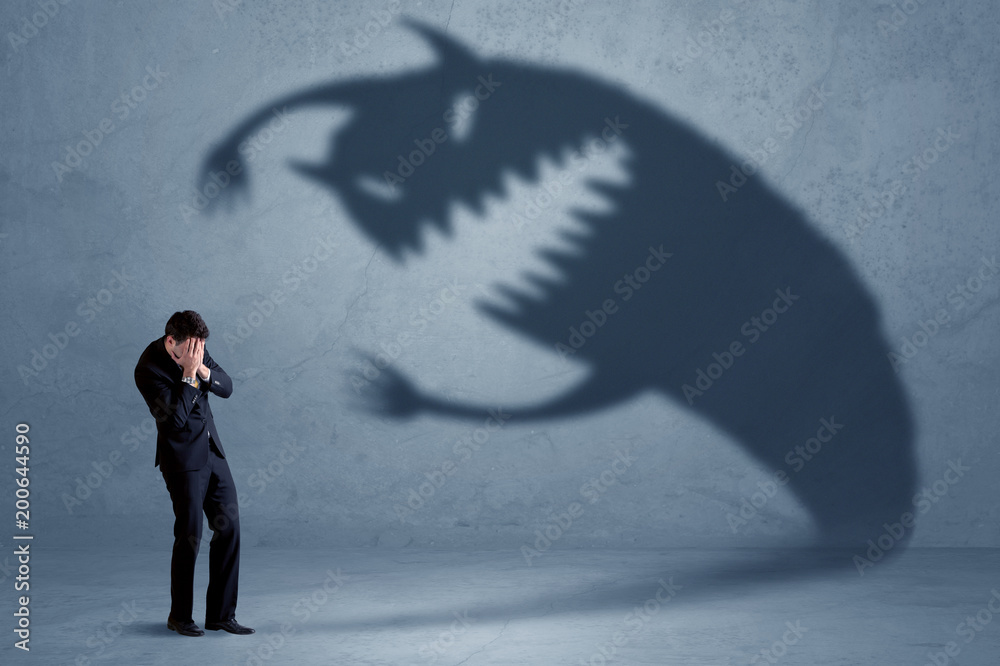 Business man afraid of his own shadow monster concept on grungy background