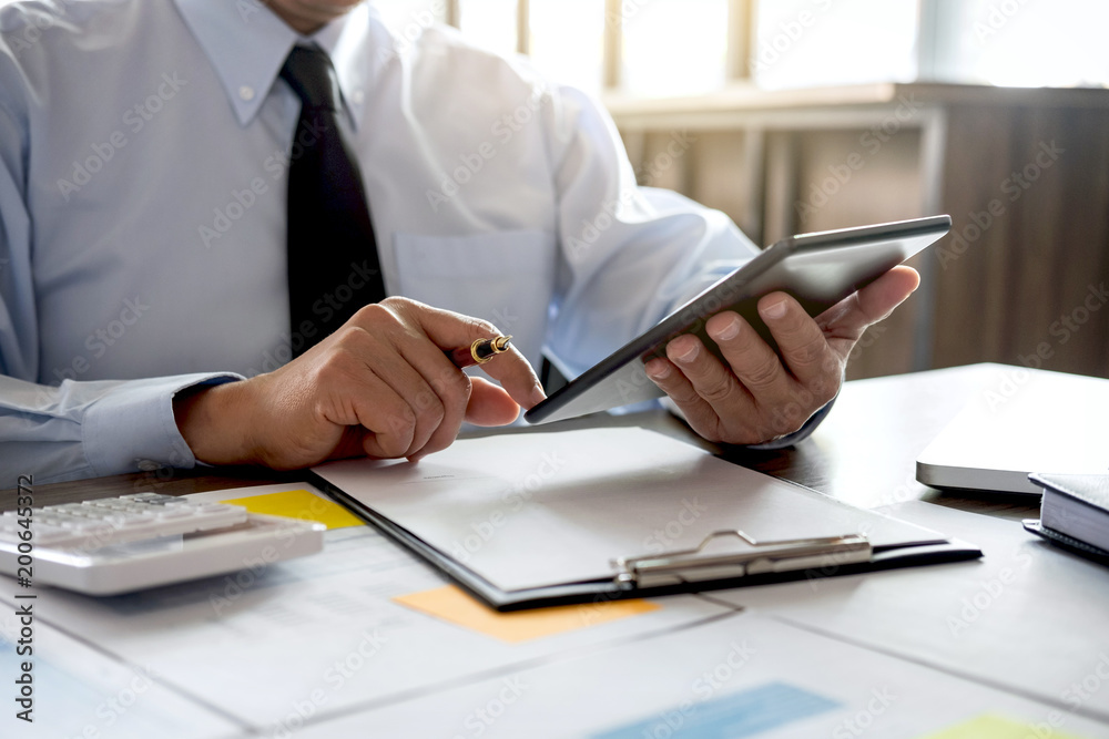 Business Financing Accounting Banking Concept, businessman using tablet and doing finances, calculate about cost to real estate investment and in other, tax system Business Financing Accounting Banking Concept, businessman using tablet and doing finances, calculate about cost to real estate investment and in other, tax system