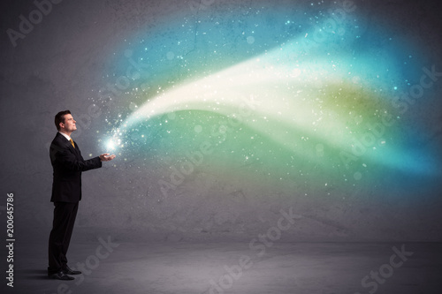фотографія Caucasian businessman holding aurora borealis kind of stria of light