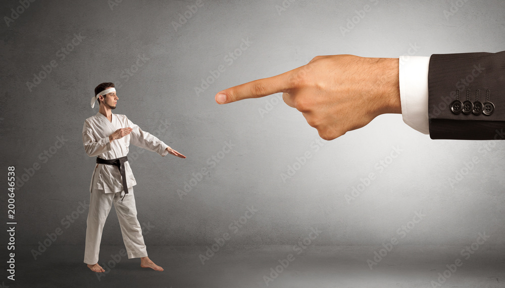 Small karate man fighting with big hand Small karate man fighting with big hand